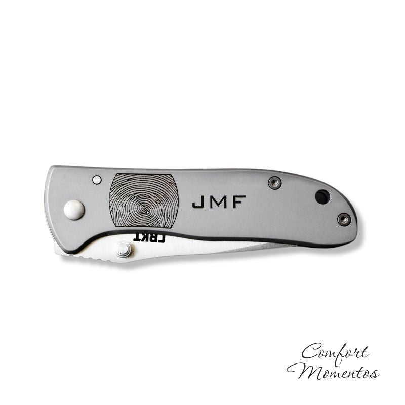 Folded stainless steel pocket knife engraved with black fingerprint and JMF