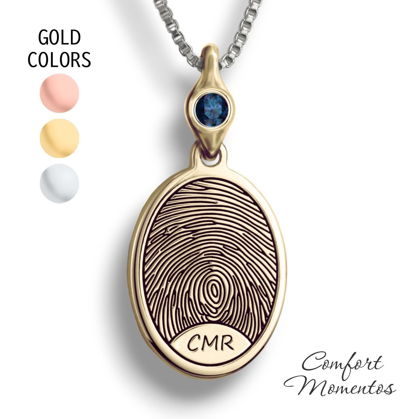 Gold oval necklace with a black fingerprint and initials engraved, with a gemstone urn