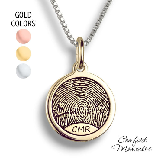 Gold round necklace with a black fingerprint and initials engraved