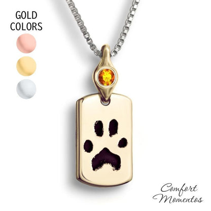 Small gold dog tag necklace with black pawprint engraving, with a gemstone urn