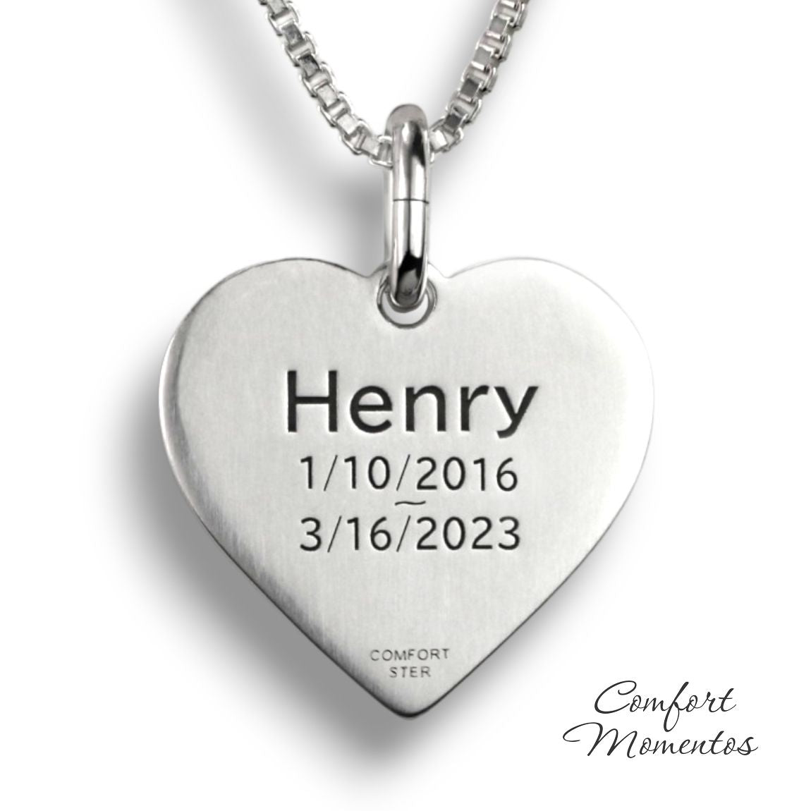 Back of silver heart necklace with example text engraved in black letters