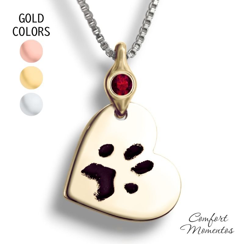 Gold tilted heart necklace with black pawprint engraving, with a gemstone urn