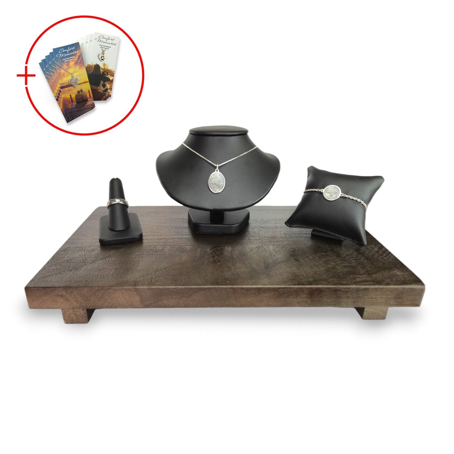 Fingerprint jewelry displayed on black leather, with a wooden base