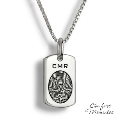 Small silver dog tag necklace with a black fingerprint and initials engraved