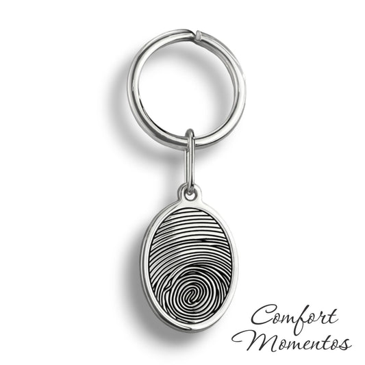 Silver oval keychain with a black fingerprint engraved, on a round split key ring