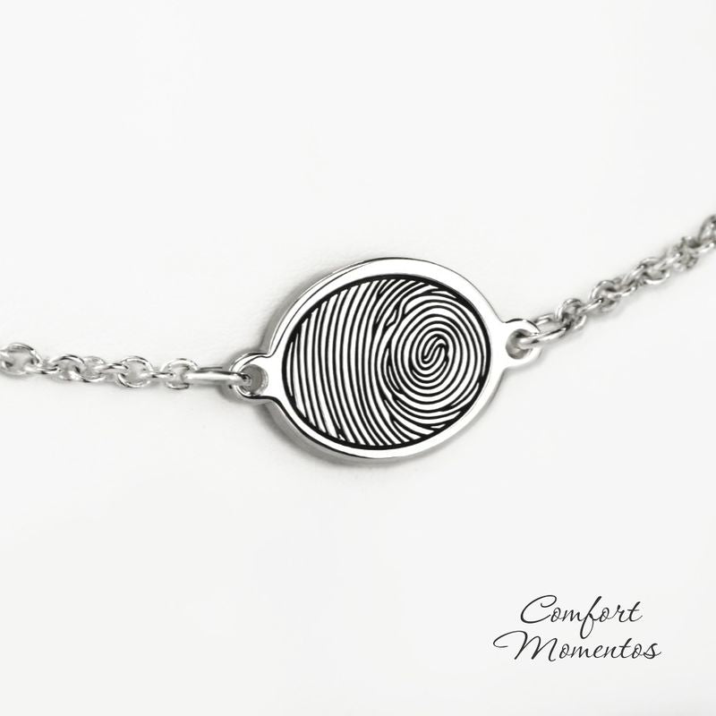 Silver oval charm bracelet engraved with a black fingerprint, with a rounded cable chain