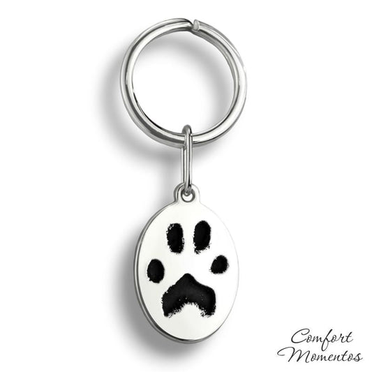 Silver oval keychain with black pawprint engraving, on a round split key ring
