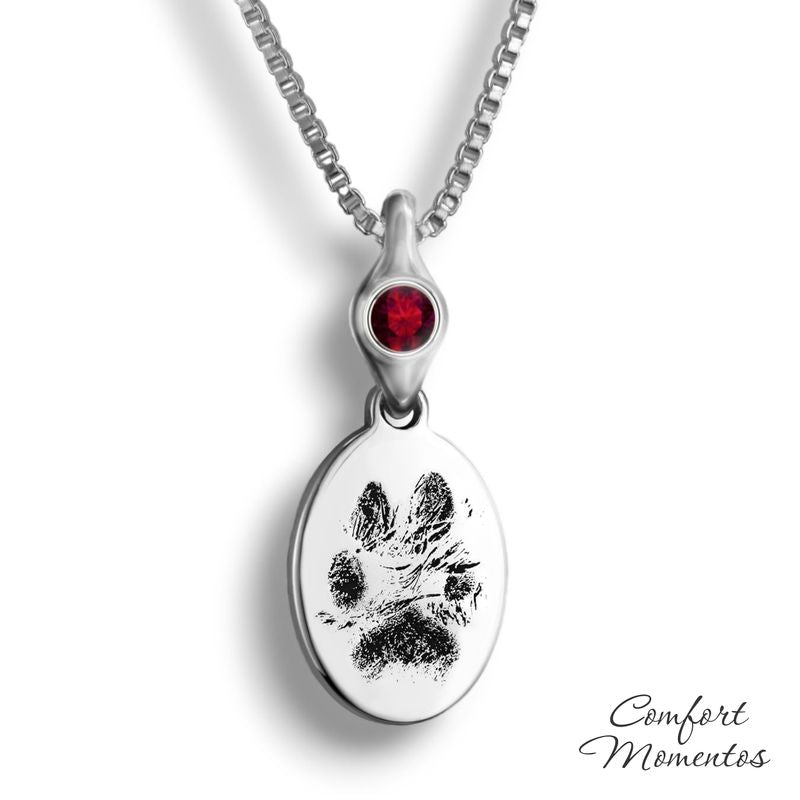 Small silver oval necklace with black pawprint engraving, with a gemstone urn