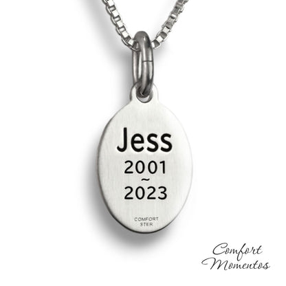 Back of small silver oval necklace, with black example text engraved