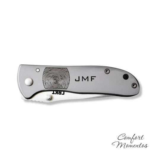 Folded stainless steel pocket knife engraved with black fingerprint and JMF
