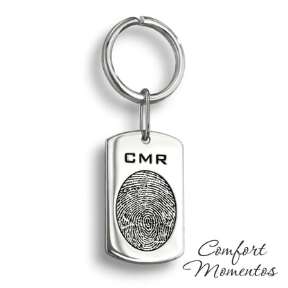 Silver dog tag keychain with a black fingerprint and initials engraved, on a round split key ring
